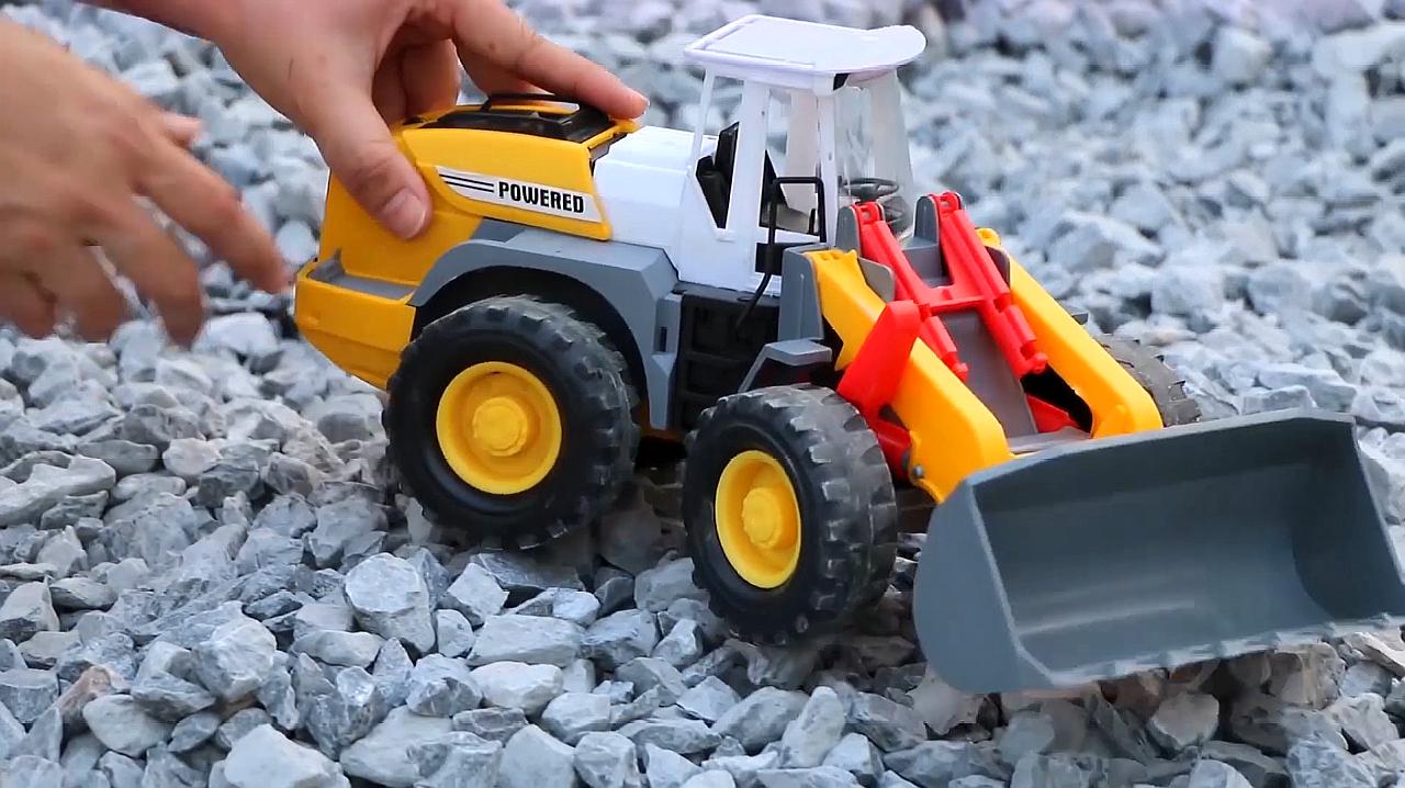 这里有两辆迷你的挖掘机和翻斗车,它们正在开心的玩石子呢