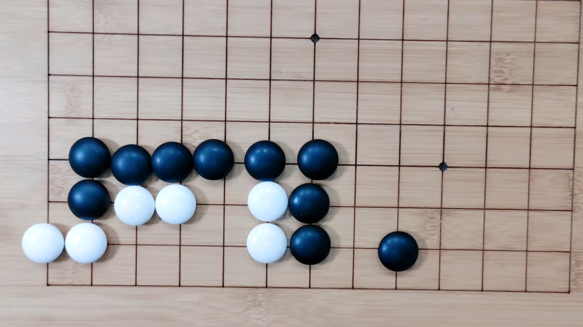 1围棋技巧:首先黑棋先下一子缩小眼位,然后白棋关门,黑棋一扳,这样白